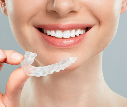 girl holding clear aligner